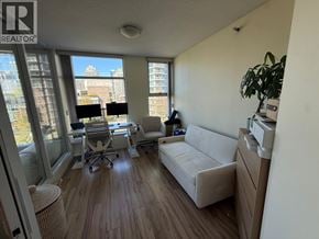 Vancouver apartment for rent - A living room with a couch, chair, and desk with a view of the city.