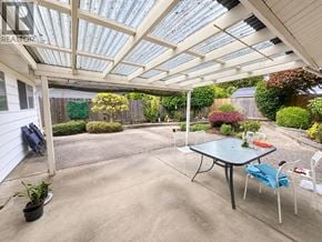 North Vancouver apartment for rent - A patio with a table and chairs under a glass roof.