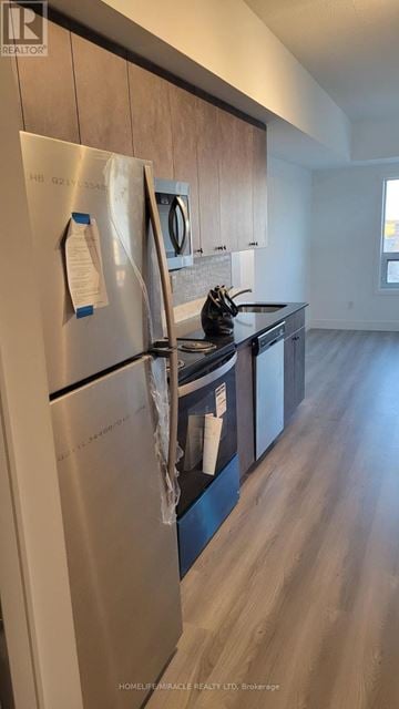 Brantford condo for rent - A stainless steel refrigerator with a note attached to it in a kitchen.