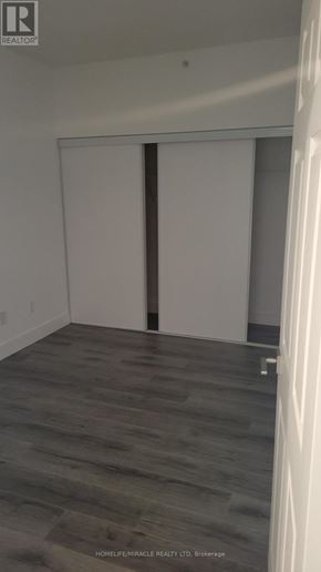 Brantford condo for rent - A room with a sliding door and wooden flooring.