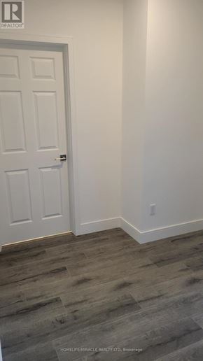 Brantford condo for rent - A white door is in a room with a wooden floor.