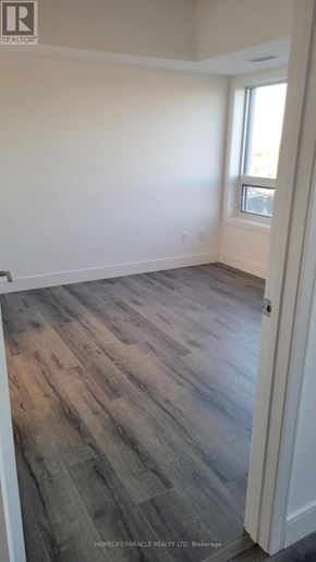 Brantford condo for rent - A room with wooden flooring and a window.