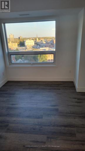 Brantford condo for rent - A room with a large window overlooking a cityscape.