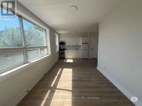Toronto (Mimico) condo for rent - A sunny room with wooden floors and white walls.