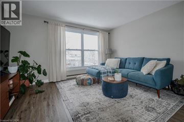 Cambridge townhouse for rent - A blue couch sits in a living room with a large window behind it.
