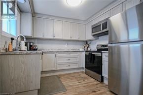 Cambridge townhouse for rent - A modern kitchen with a stainless steel refrigerator and wooden cabinets.