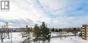 Guelph condo for rent - A snowy landscape with a building on the right side.