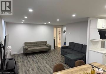 Guelph condo for rent - A living room with a grey couch and a wooden table.