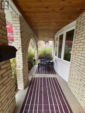 St. Catharines (Lakeport) apartment for rent - A striped rug is on a patio with a black grill.