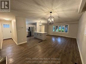 St. Catharines (Lakeport) apartment for rent - A well-lit, empty room with wooden floors and a chandelier.
