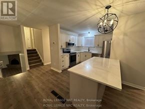 St. Catharines (Lakeport) apartment for rent - A kitchen with a white countertop and a chandelier hanging from the ceiling.