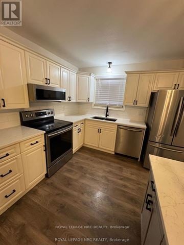 St. Catharines (Lakeport) apartment for rent - A kitchen with wooden cabinets and a black stove top oven.