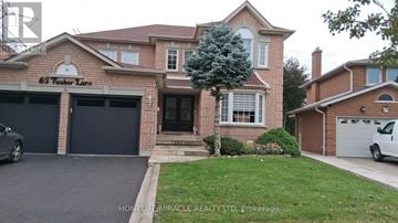 Vaughan (East Woodbridge) apartment for rent - A brick house with a garage and a tree in front.