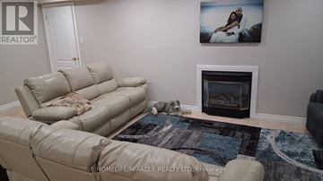 Vaughan (East Woodbridge) apartment for rent - A living room with a beige couch and a fireplace.