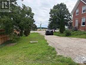 Erin apartment for rent - A car is parked on a gravel driveway in front of a house.