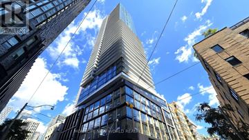 Toronto (Church-Yonge Corridor) condo for rent - A tall building with the words "World Realty" on the side is seen from below.