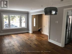Richmond Hill (Crosby) apartment for rent - A room with wooden floors and a large window with a view of cars and trees outside.