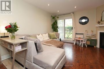 Oakville (Ga Glen Abbey) condo for rent - A living room with a grey couch and a wooden table.
