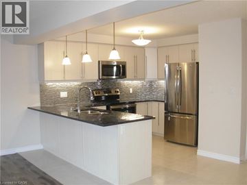 Kitchener townhouse for rent - A modern kitchen with a black countertop and stainless steel appliances.