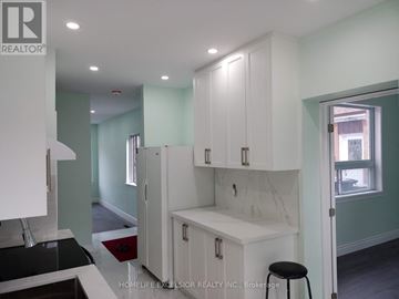 Toronto (Woburn) apartment for rent - A kitchen with white cabinets and a black counter top.