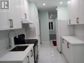 Toronto (Woburn) apartment for rent - A kitchen with white cabinets and a black stove top oven.