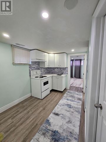 Toronto (Woburn) apartment for rent - A kitchen with white appliances and cabinets is shown.