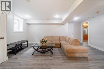 Ancaster apartment for rent - A living room with a sofa, coffee table, and a glass table with flowers on it.