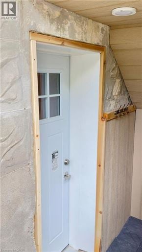 Kitchener apartment for rent - A white door with a handle and a lock is in a room with a brown wooden frame.