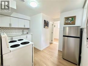 Kitchener apartment for rent - A kitchen with white cabinets and a stove top oven.
