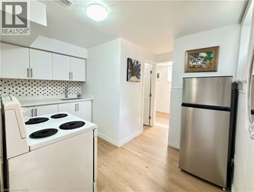 Kitchener apartment for rent - A kitchen with white cabinets and a stove top oven.