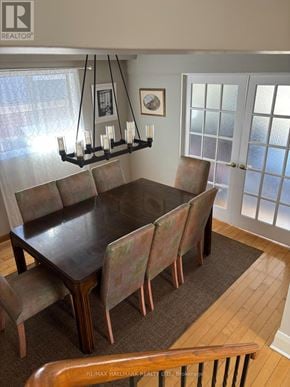 Toronto (Cliffcrest) apartment for rent - A brown dining table with chairs and a chandelier in a room.