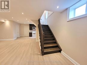 Toronto (Oakridge) apartment for rent - A spacious room with a staircase leading to the upper floor.