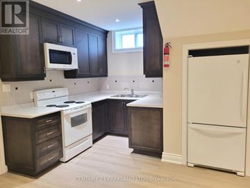 Toronto (Oakridge) apartment for rent - A kitchen with dark wood cabinets and white appliances.