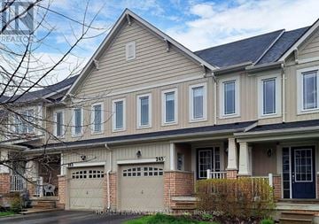 Bradford West Gwillimbury (Bradford) townhouse for rent - A two-story house with a garage on the first floor and a front porch with a door.