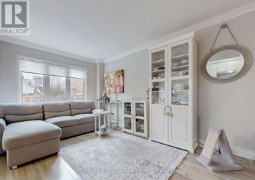Bradford West Gwillimbury (Bradford) townhouse for rent - A living room with a grey sofa and a glass cabinet.