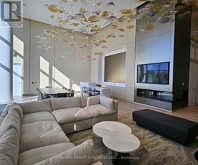 Mississauga (Port Credit) condo for rent - A modern living room with a large sectional sofa and a flat screen TV.