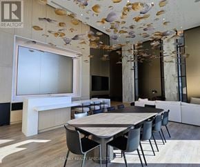 Mississauga (Port Credit) condo for rent - A modern dining room with a table set for six and a ceiling decoration of shells.