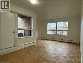 Hamilton apartment for rent - A room with a wooden floor and a window overlooking a cityscape.