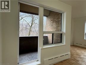 Hamilton apartment for rent - A room with a window that has a view of a tree and a building.