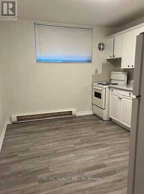 Grimsby (Grimsby East) townhouse for rent - A kitchen with white appliances and a window with blinds.