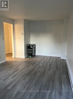 Grimsby (Grimsby East) townhouse for rent - A room with a wooden floor and a white wall with a door.