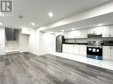 Oshawa (Eastdale) apartment for rent - A spacious kitchen with white cabinets and a stainless steel refrigerator.