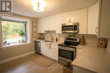 Ottawa apartment for rent - A kitchen with white cabinets and a marble countertop.