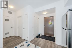 Waterloo condo for rent - A hallway with a door on the right and a fridge on the left.
