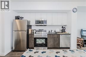 Waterloo condo for rent - A modern kitchen with a stainless steel refrigerator and wooden cabinets.