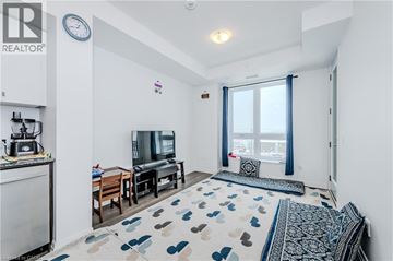 Waterloo condo for rent - A living room with a television, a sofa, and a rug with a heart pattern.