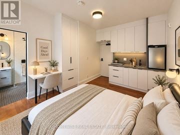 Toronto (High Park-Swansea) multi-family for rent - A bedroom with a bed, desk, and kitchen area.
