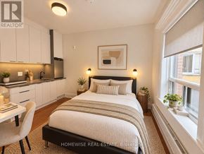 Toronto (High Park-Swansea) multi-family for rent - A bedroom with a bed, chair, and a framed picture on the wall.
