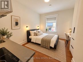 Toronto (High Park-Swansea) multi-family for rent - A bedroom with a bed, chair, and window.