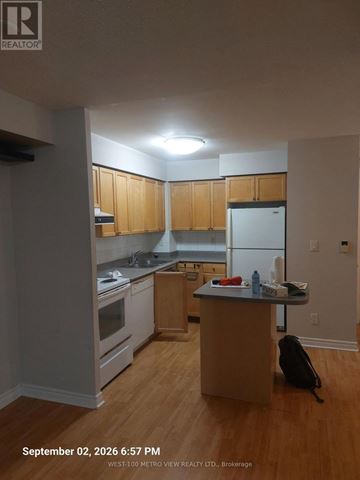 Mississauga (City Centre) condo for rent - A kitchen with wooden cabinets and a white refrigerator.